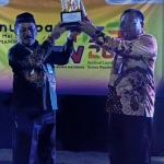 Kepala SMAN 1 Sumenep Drs. Rafiudin, M.Pd, saat menerima Tropy Juara Umum yang diserahkan langsung oleh Kepala Cabang Dinas Pendidikan Provinsi Jawa Timur Wilayah Kabupaten Sumenep Dr. Budi Sulistyo, S.Pd., M.Si